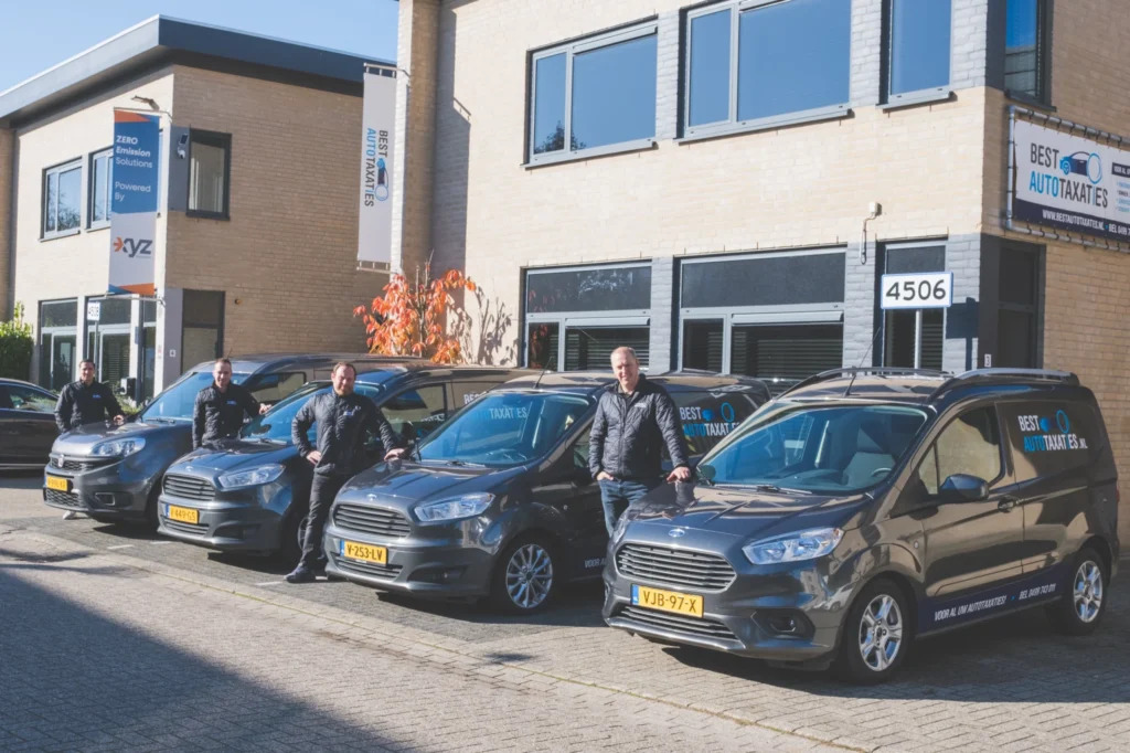 Teamfoto met bedrijfsauto's bij Best Autotaxaties